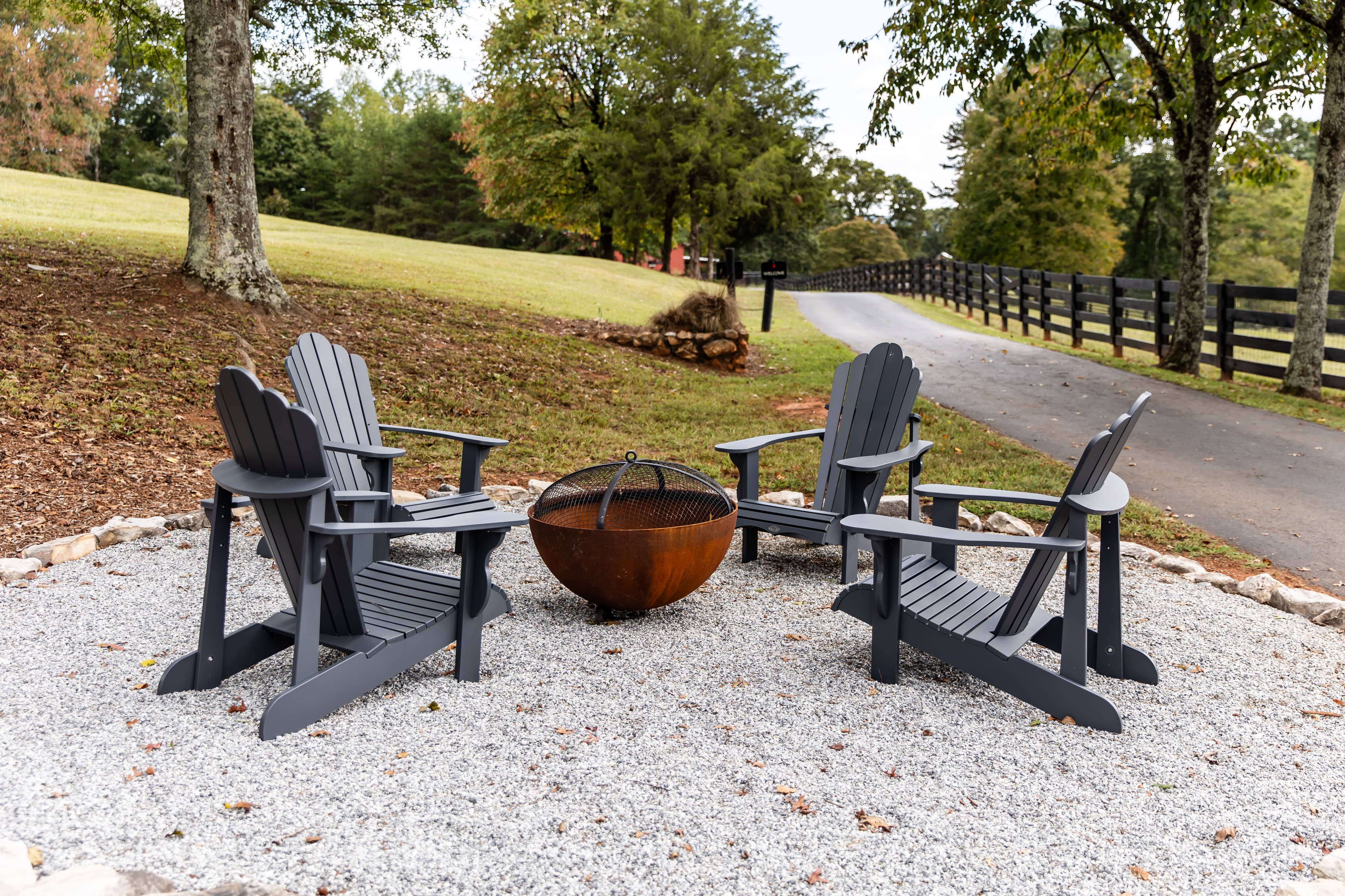 Metal Firepit with four Adirondack chairs